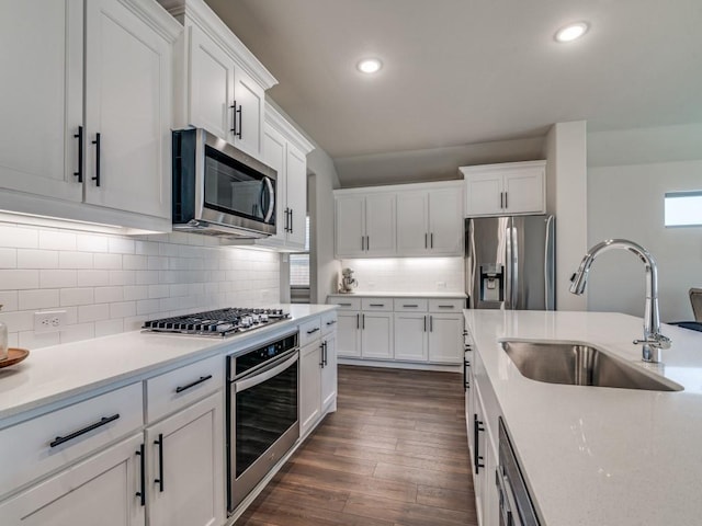 kitchen featuring dark wood-style floors, light countertops, appliances with stainless steel finishes, white cabinets, and a sink