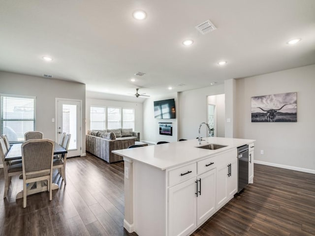 kitchen featuring dark wood-style flooring, light countertops, visible vents, stainless steel dishwasher, and a sink