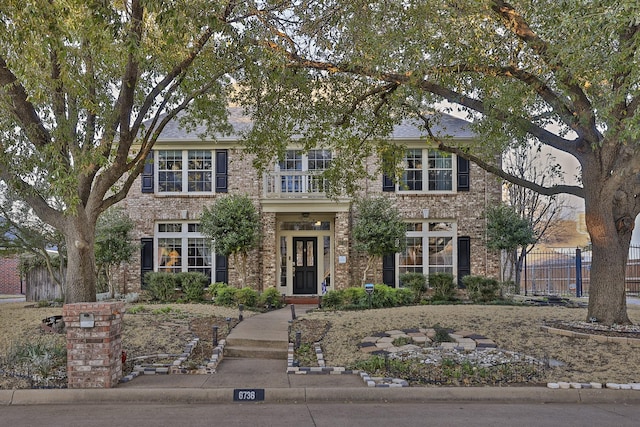 view of front of home featuring brick siding and fence