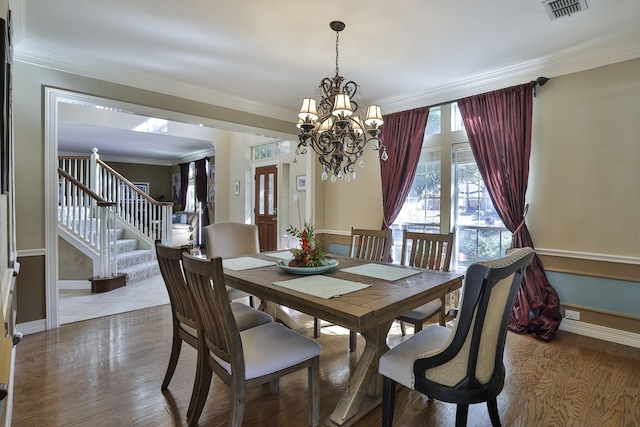 dining area with baseboards, visible vents, stairway, ornamental molding, and wood finished floors