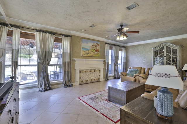 living area featuring crown molding, a fireplace, visible vents, light tile patterned flooring, and a textured ceiling