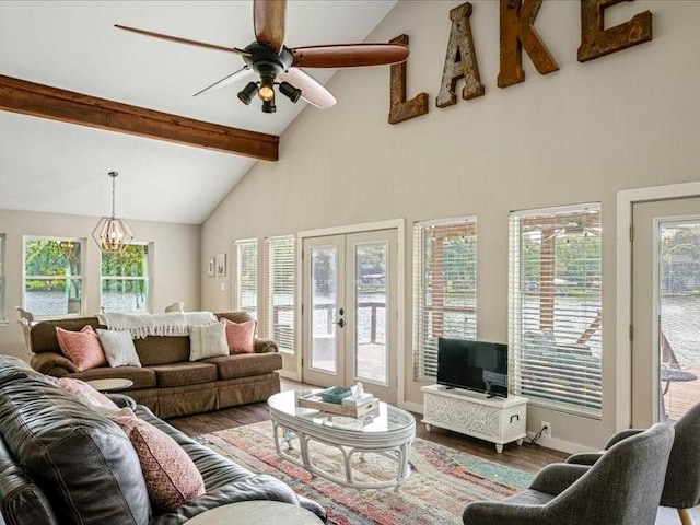 living room featuring high vaulted ceiling, ceiling fan with notable chandelier, wood finished floors, french doors, and beam ceiling