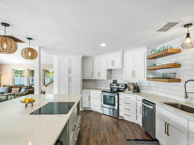 kitchen featuring a sink, visible vents, white cabinets, hanging light fixtures, and appliances with stainless steel finishes