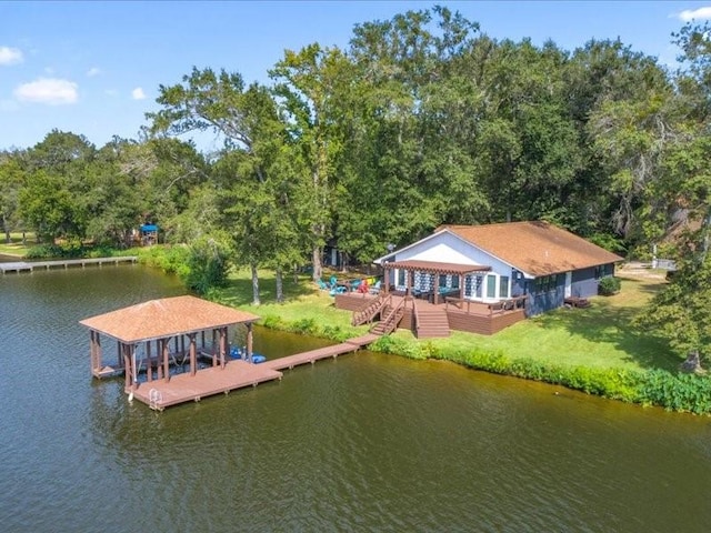 view of dock with a yard, a deck with water view, and boat lift