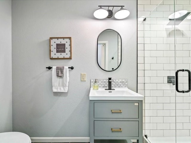 full bathroom featuring toilet, a shower stall, tasteful backsplash, and vanity