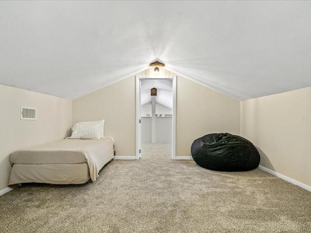 bedroom with vaulted ceiling, carpet flooring, visible vents, and baseboards