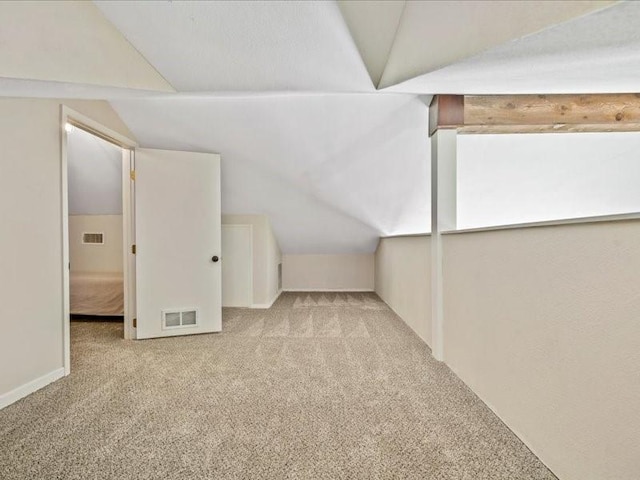 bonus room featuring lofted ceiling, carpet flooring, and visible vents