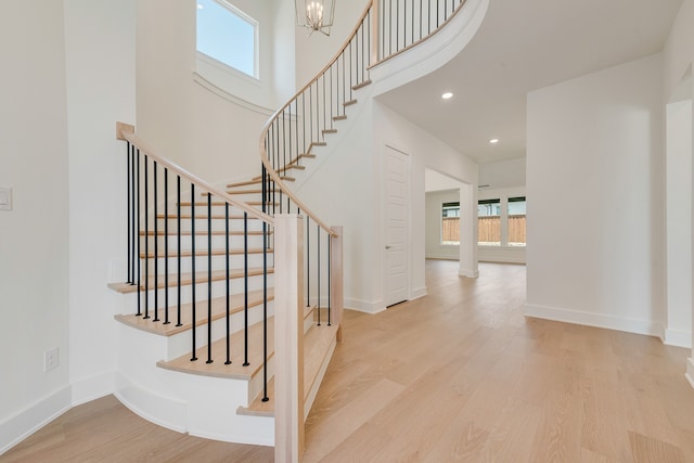 830 Montrose Dr, Rockwall, TX 75087 - stairway featuring healthy amount of natural light, wood finished floors, a chandelier, a high ceiling, and recessed lighting