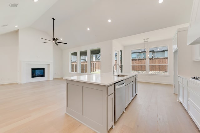 830 Montrose Dr, Rockwall, TX 75087 - kitchen with dishwasher, light wood-style flooring, light countertops, a kitchen island with sink, and a ceiling fan