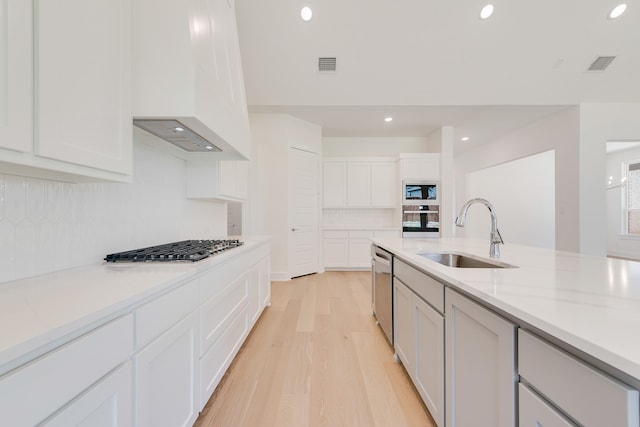 830 Montrose Dr, Rockwall, TX 75087 - kitchen with appliances with stainless steel finishes, custom range hood, decorative backsplash, light wood-style floors, and recessed lighting