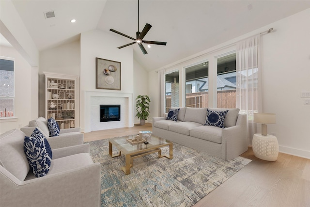830 Montrose Dr, Rockwall, TX 75087 - living area with ceiling fan, a glass covered fireplace, wood finished floors, high vaulted ceiling, and recessed lighting