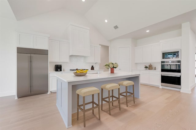 830 Montrose Dr, Rockwall, TX 75087 - kitchen with built in appliances, high vaulted ceiling, tasteful backsplash, a breakfast bar area, and white cabinetry