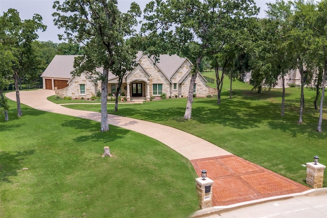 view of front of house with a garage, stone siding, and a front lawn