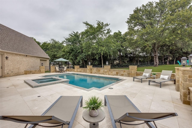 view of pool with a patio, a lawn, fence, and a pool with connected hot tub