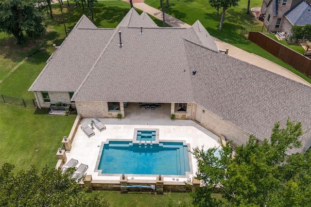 view of swimming pool featuring a patio, a fenced backyard, a pool with connected hot tub, a boat dock, and a lawn