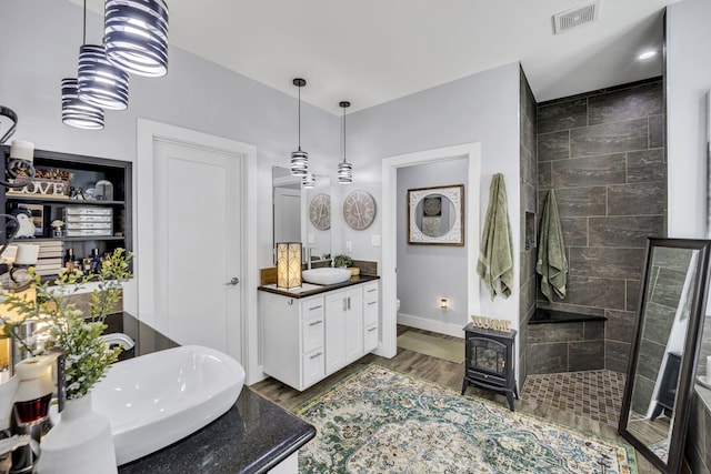 19909 County Road 1102, Flint, TX 75762 - full bath with a wood stove, walk in shower, baseboards, vanity, and wood finished floors