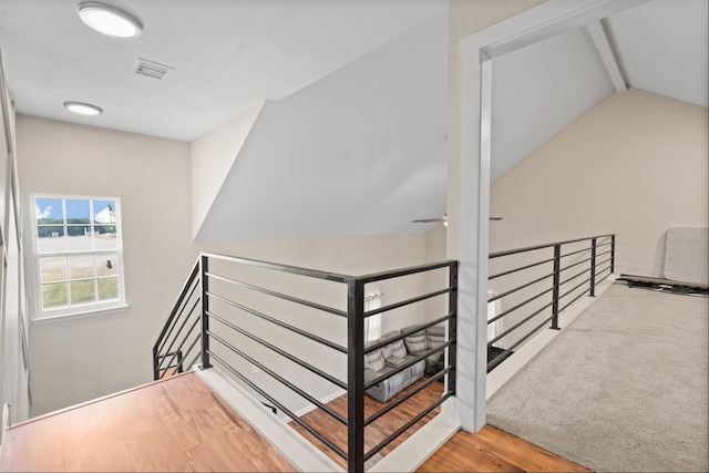 staircase featuring vaulted ceiling with beams, wood finished floors, visible vents, and a ceiling fan