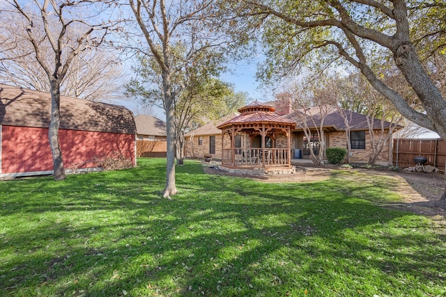 exterior space featuring a gazebo, an outbuilding, and fence