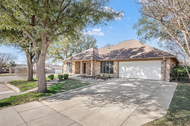 view of front of house featuring driveway, brick siding, an attached garage, and a shingled roof