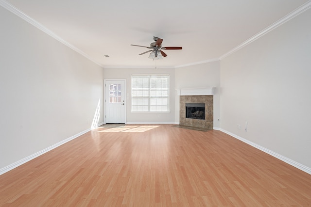 unfurnished living room featuring light wood-style flooring, baseboards, crown molding, and a tile fireplace