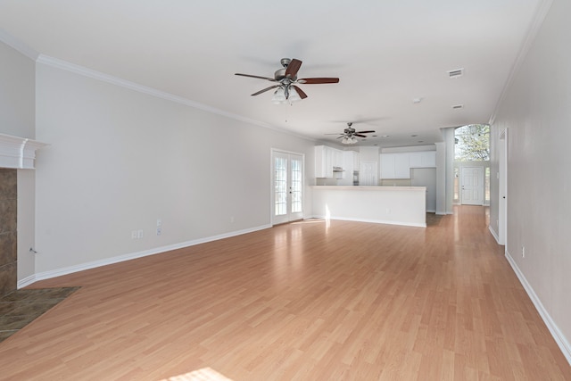 unfurnished living room featuring light wood-type flooring, visible vents, crown molding, and baseboards