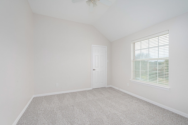 carpeted spare room featuring vaulted ceiling, ceiling fan, and baseboards