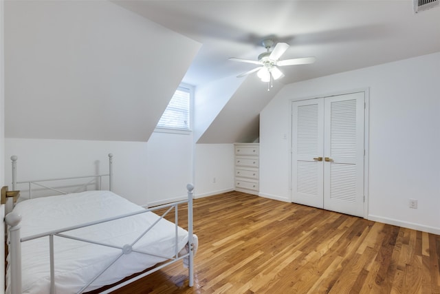 bedroom featuring lofted ceiling, baseboards, visible vents, and light wood finished floors