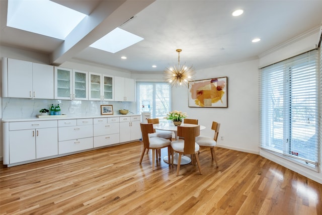 dining room with recessed lighting, baseboards, light wood finished floors, an inviting chandelier, and crown molding