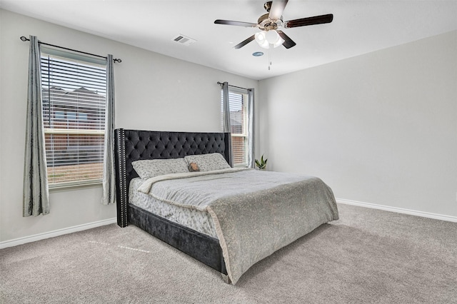 carpeted bedroom with visible vents, baseboards, and a ceiling fan