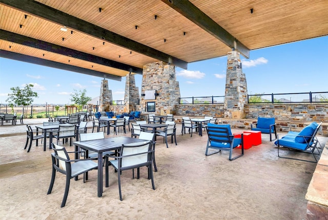 view of patio / terrace with an outdoor stone fireplace and fence