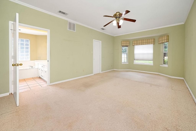 spare room with baseboards, ornamental molding, visible vents, and light colored carpet