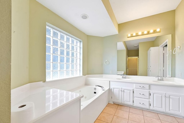 full bath with double vanity, a jetted tub, a sink, and tile patterned floors