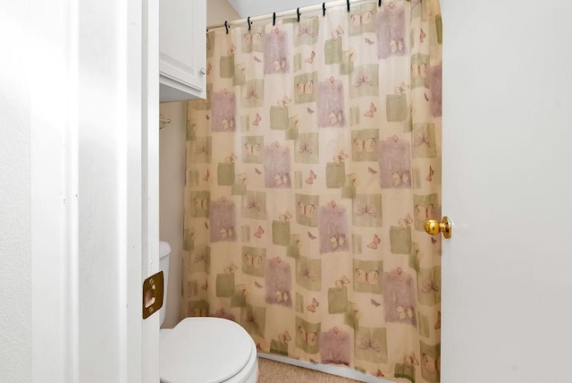 bathroom featuring a shower with curtain and toilet