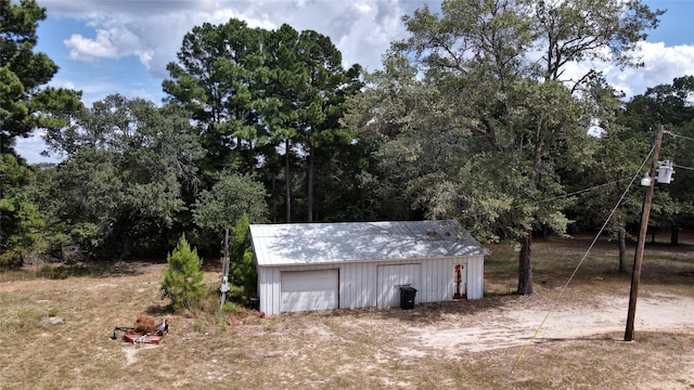 view of outdoor structure with dirt driveway and an outdoor structure