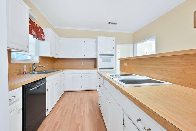 kitchen with light countertops, visible vents, white cabinets, a sink, and white appliances