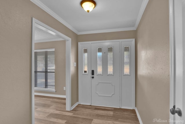 foyer with baseboards, crown molding, and wood finished floors