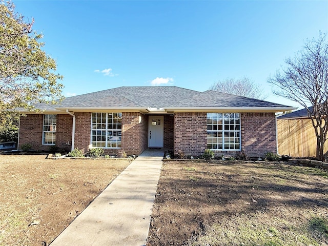 single story home with a shingled roof and brick siding