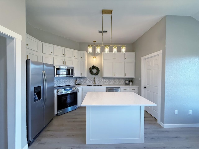 kitchen with appliances with stainless steel finishes, light countertops, and white cabinets