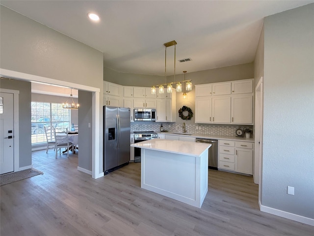 kitchen featuring visible vents, appliances with stainless steel finishes, white cabinets, and backsplash