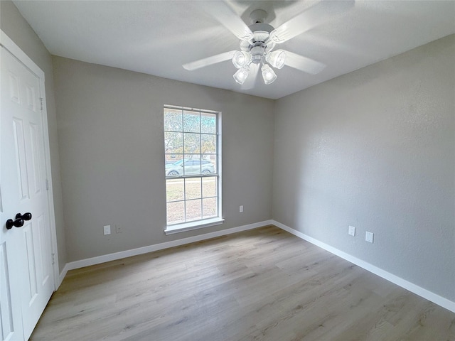 unfurnished room featuring light wood-style floors, ceiling fan, and baseboards