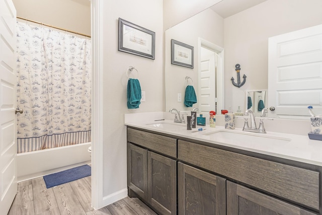 full bathroom featuring double vanity, wood finished floors, a sink, and shower / bathtub combination with curtain