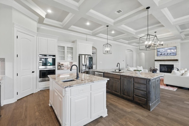 kitchen featuring an island with sink, visible vents, appliances with stainless steel finishes, and a sink