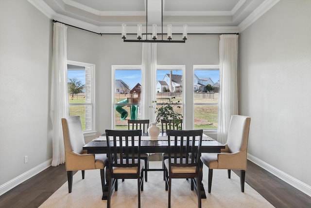 dining space with baseboards, ornamental molding, and wood finished floors