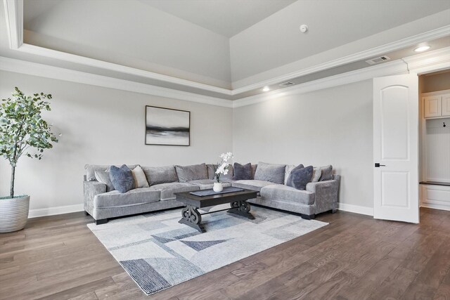 living room featuring a tray ceiling, dark wood-style flooring, visible vents, and baseboards