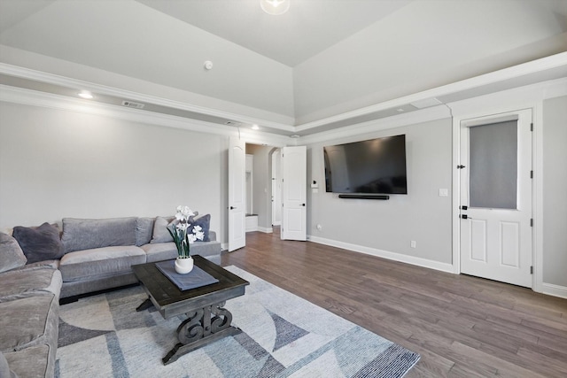 living area with arched walkways, lofted ceiling, wood finished floors, visible vents, and baseboards