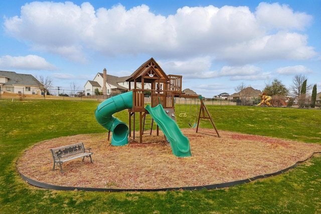 community play area featuring a residential view, fence, and a lawn