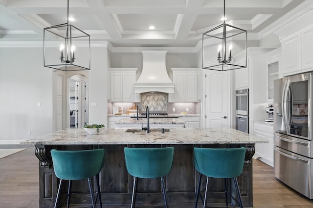 kitchen featuring arched walkways, dark wood finished floors, custom exhaust hood, stainless steel appliances, and an inviting chandelier