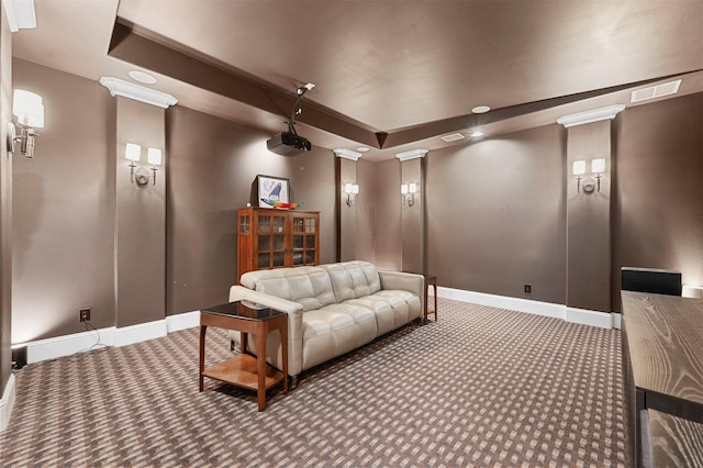 carpeted cinema featuring a raised ceiling, visible vents, decorative columns, and baseboards