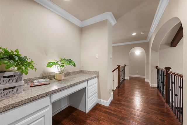 hallway featuring arched walkways, ornamental molding, dark wood-type flooring, an upstairs landing, and baseboards