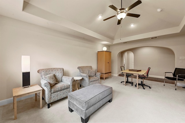 sitting room featuring light carpet, arched walkways, visible vents, and lofted ceiling